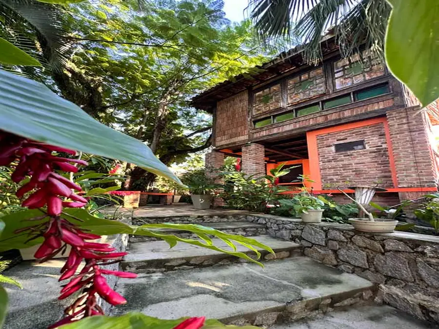 Jardim tropical exuberante e arborizado na Pousada 4 Ventos em Arraial d'Ajuda.