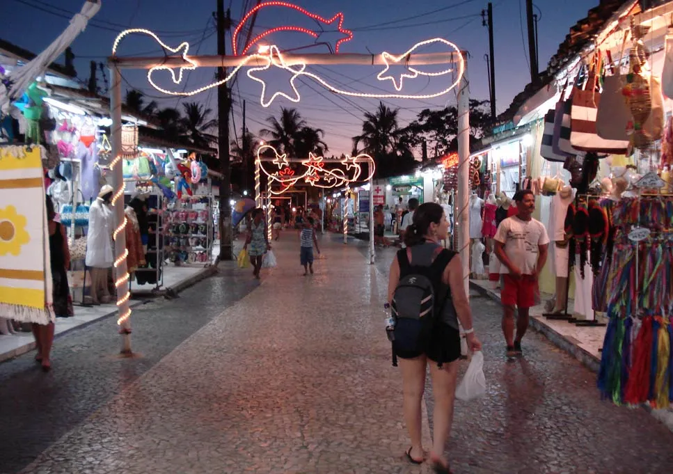 Rua Broadway colorida e movimentada, cartão-postal turístico próximo à Pousada 4 Ventos em Arraial d'Ajuda.